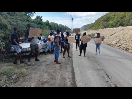 Protesters line a section of the Grants Pen main road in St Thomas on Wednesday, the first day of a two-day demonstration.
