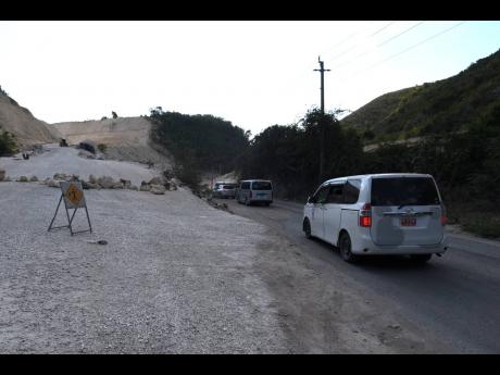 Motorists drive past the South Coast Highway route that is expected to open soon. Residents of Grants Pen protested for two days against the longer route to leave the community, which they say is an inconvenience.