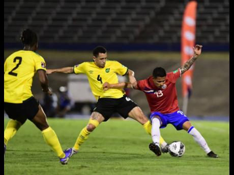 
Jamaica’s Ravel Morrison (centre) contests Costa Rica’s Gerson Torres for possession while Reggae Boy Gregory Leigh monitors the action in a Concacaf World Cup qualifier at the National Stadium in Kingston on Wednesday. 