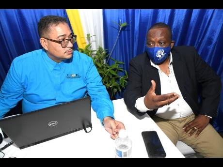 Deryke Smith (left), CEO of COK Sodality, chats with Clive Medwynter, president of COK, at the COK Sodality Co-operative Credit Union annual staff meeting.