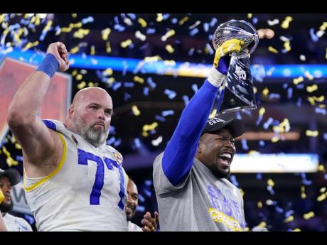 Los Angeles Rams outside linebacker Von Miller (right) holds up the Lombardi Trophy while celebrating with offensive tackle Andrew Whitworth (77) after defeating the Cincinnati Bengals in the NFL Super Bowl 56 game Sunday in Inglewood, California. 