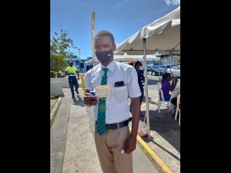 Calabar High School student Jordan Turner displays his vaccination card at the fourth port community vaccination blitz put on by the Ministry of Health and Wellness at Kingston Wharves recently. 