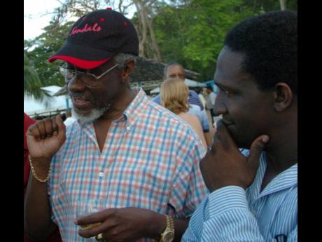 Journalist Winston Witter listens to then Prime Minister P.J. Patterson at a media party in St Ann on January 16, 2005. 