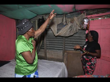 Irene Morgan and her daughter, Nathalie Francis, of Corn Hill in Smithville, Clarendon, show sections of the damaged roof and a section of the wall that has collapsed and has been patched with sheets of zinc at their home. They are worried that the structu