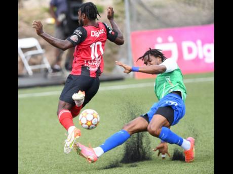 
Arnett Gardens’ Ajuma Johnson (left) takes evasive action from Montego Bay United’s Nevaun Turner’s crunching challenge during a Jamaica Premier League game at the UWI-JFF Captain Horace Burrell Centre of Excellence yesterday.