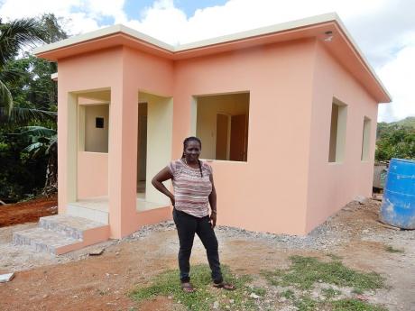 Andrea Riley stands in front of her house, which is under construction.