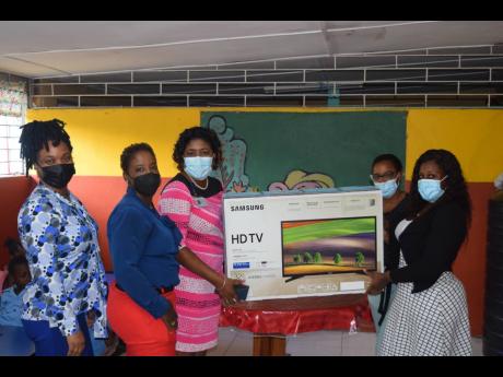 From left: Staff members of the Shipping Association of Jamaica Vershema Vickers, Jean Hinds-Bell and Debbie Ann Dobson present a smart television to principal of Marcus Garvey Basic School, Judonna Smikle, and teacher Simone Rose-Ferrant. 