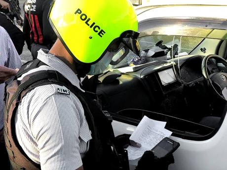 
A policeman utilising the new e-ticketing system to check a motorist’s car documents.