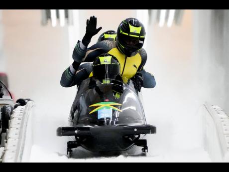 
Shanwayne Stephens, Ashley Watson, Rolando Reid and Matthew Wekpe, of Jamaica, arrive to the finish area after the four-man heat 2 at the 2022 Winter Olympics on Saturday, February 19, 2022, in the Yanqing district of Beijing. 