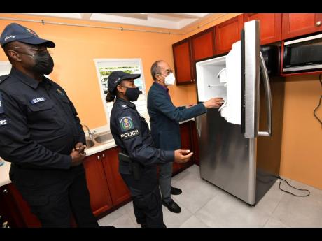 ACP Warren Clarke (left), Sherika Service (centre), superintendent of police give Dr Horace Chang, deputy prime minister and minister of national security a tour of the renovated areas of the Harman Barracks in Kingston on yesterday.