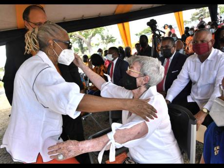 Beverley Anderson Duncan (left), former wife of late former prime minister Michael Manley, greets Glynn Manley, his widow, during a wreath-laying ceremony commemorating the 25th anniversary of Manley’s death. Some of his social and legislative reforms in