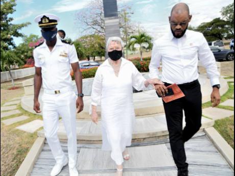 Glynne Manley, widow of former Prime Minister Michael Manley, is escorted by Raymond Pyrce (right) and Scott Renardo.
