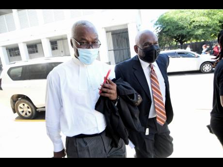 Colin Campbell (right) is accompanied by attorney-at-law Bert Samuels outside the Supreme Court building on Tuesday. Campbell will continue giving testimony at the Trafigura hearing today. 