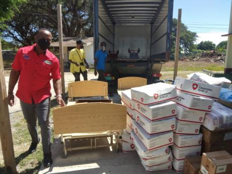 Robert White, director of Sanmerna Foundation Ltd and managing director of Sanmerna Paper Products, standing beside some of the supplies that were donated.