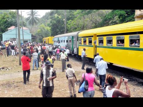 Residents of Bog Walk, St Catherine, converge at the local train station for a closer view of the re-conditioned five-coach train, on its test run from May Pen, Clarendon to Linstead.
