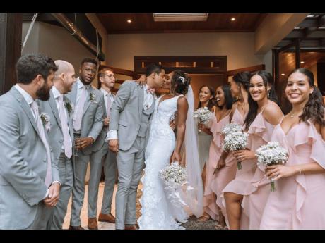 The newly-weds could hardly keep their hands off each other, or even focus on taking pictures with their bridal party, as they get lost in a kiss.