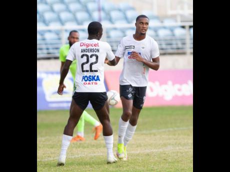 Cavalier’s Christopher Pearson (right) is congratulated by teammate Collin Anderson after he scored a penalty against Molynes United during their Jamaica Premier League match at Sabina Park yesterday.