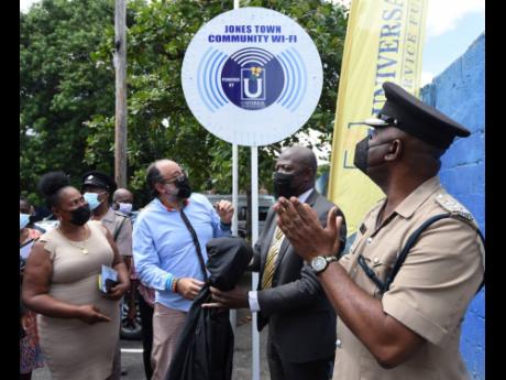 Louise Newland (left), community member, Admiral Town; Mark Golding (second left), leader of the Opposition and member of parliament, St Andrew Southern; Daniel Dawes (second right) CEO, Universal Service Fund (USF) and Senior Superintendent of Police *-Mi