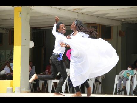 Miguel Ford and Isheba Daniels, members of the culture club at Garvey Maceo High, celebrate the life of late teacher Ann-Marie Robb in dance on Sunday.