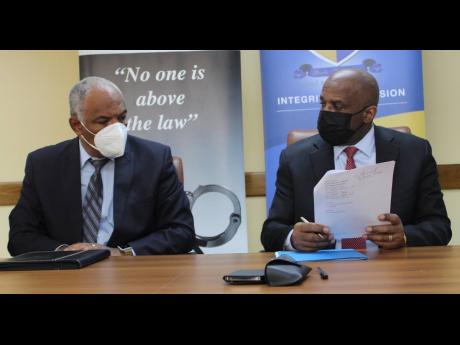 Colonel Desmond Edwards, director general of the Major Organized Crime and Anti-Corruption Agency (MOCA), and Integrity Commission Executive Director Greg Christie in dialogue during the signing of a memorandum of understanding to increase corporation betw