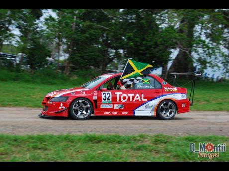 David Summerbell Jr flying the Jamaican flag and the checkered flag high after winning a race in the Caribbean Championship.