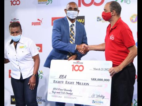 Don Wehby (right) CEO of GraceKennedy Group presents a sponsorship cheque to Keith Wellington, President of the Inter-secondary Schools Sports Association (ISSA) at the media launch for the 2022 ISSA/ GraceKennedy Boys and Girls’ Athletics at the Nationa