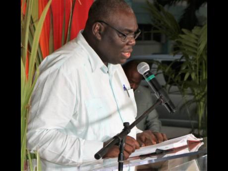 Dr Donovan Stanberry, registrar at The University of the West Indies, Mona campus, reads from his book, ‘How Trade Liberalization Affects a Sugar-Dependent Community in Jamaica: Global Action; Local Impact’ at the UWI Undercroft on Wednesday.