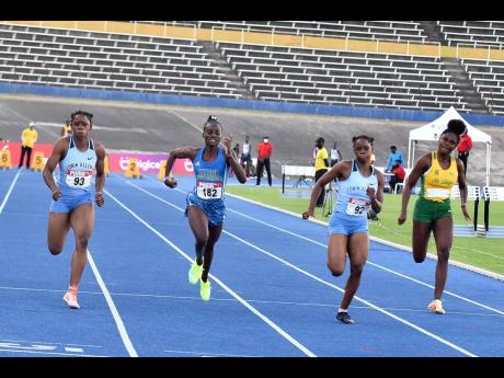 Edwin Allen’s Tia Clayton (left) wins the JAAA Carifta Trials girls’ under-20 100-metre event ahead of her sister Tina Clayton (second right) at the National Stadium recently. 