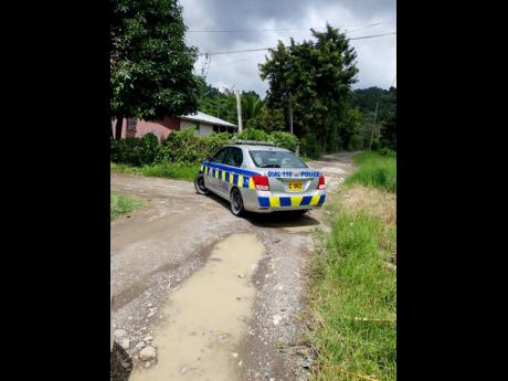 A police service vehicle is seen in Bath, St Thomas, Thursday as lawmen visited the home of the nine-year-old abduction victim of suspect Davian Bryan.
