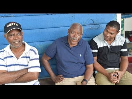 
From left: Hylton Ewan, former porter at the Catadupa train station and Jamaica Railway Corporation (JRC) employee; JRC CEO Donald Hylton; and Randy Ebanks, JRC technical administrative assistant, discussing the prospects of the return of train service to