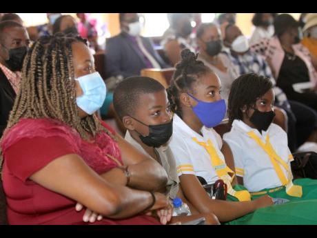 Deneice Shakespeare-Pinnock, mathematics teacher of Spalding Primary, is attentive alongside her students, Munair Riley, Hannah-Paige Mair, and Kasi Abbott, during the launch of National Mathematics Week on Sunday. 