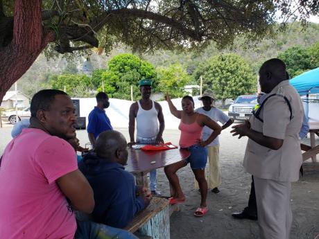 Head of St Thomas police operations, Deputy Superintendent O’Neil Thompson, engages concerned residents of Grants Pen.