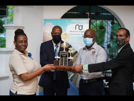 From left: Tertiary scholarship awardee Karesha Richardson being presented with the Ministry of Agriculture and Fisheries award to the top student for the academic year 2021-2022 from Joseph Gyles, CEO of the National Irrigation Commission (NIC), Agricultu