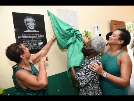 Dorleen Williams (centre), sister of the late Rev Dr Horace Russell, and Dr Elisabeth Russell-McKenzie (left) and Dr Heather Russell, his daughters, unveil a plaque in his honour at a dedication ceremony for the modern gateway of Calabar High on Tuesday. R