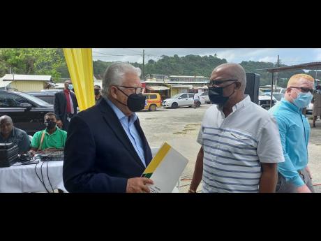 Minister of Labour and Social Security Karl Samuda (left) in a discussion with Central St Mary Member of Parliament Dr Moras Guy on Tuesday.