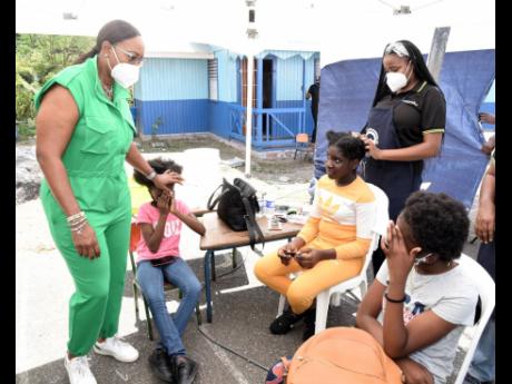 Juliet Holness (left), member of parliament, St Andrew East Rural, speaks with girls who attended the Indian High Commission Medical Camp at the St Martin de Porres Primary School in Gordon town on Sunday.  