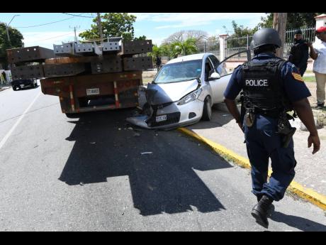
A policeman observes a Mazda motor car that was involved in a crash with a truck at Heroes Circle, Kingston, on Tuesday. There were no reports of injuries. Thirty-seven people were killed in January, a 19 per cent rise compared with the comparative period