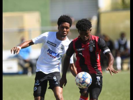 
Cavalier’s Marlando Maxwell (left) puts pressure on Kimani Arbouine of Arnett Gardens during the first round of the Jamaica Premier League at the UWI-JFF Captain Horace Burrell Centre of Excellence in January.