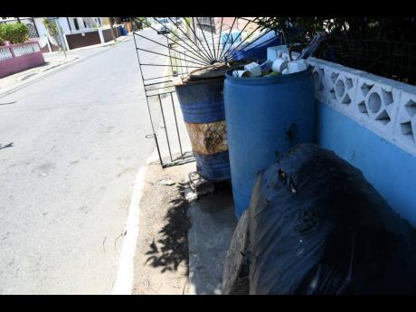 Bins overflowing with garbage in Independence City, Portmore, on Sunday.