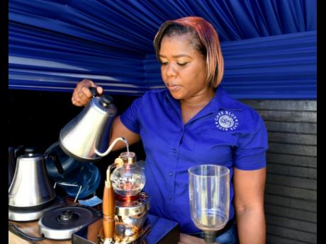 Remone Meeks, quality control manager, Café Blue, brews coffee during the Blue Mountain Coffee Festival at Devon House on Saturday.