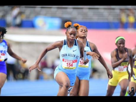 Edwin Allen High school's Tia Clayton runs with the baton during the preliminary round of the girls' Class One 4x100-metre relay at th ISSA/GraceKennedy Boys' and Girls' Athletics Championships inside the National Stadium earlier this evening.