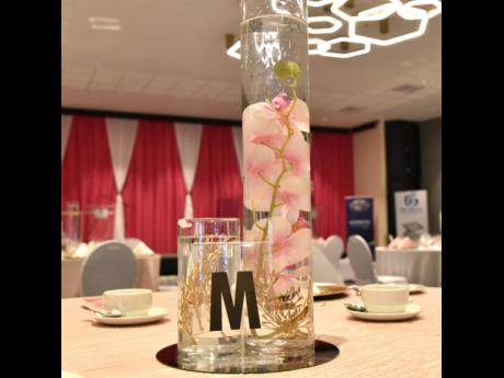 The regal centrepieces on every table had cylindrical vases with water submerged orchids which were a recurring motif in Racquel Leslie’s decor. 