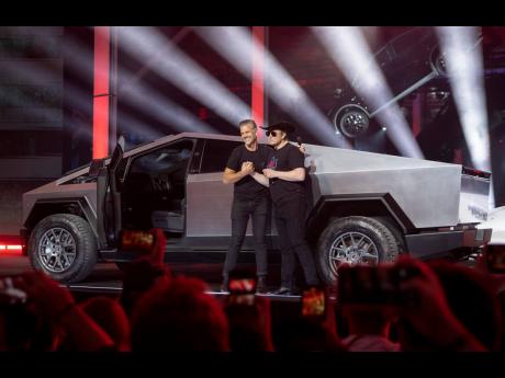 
Tesla CEO Elon Musk, right, and vehicle designer Franz von Holzhausen speak at the “Cyber Rodeo” grand opening celebration for the new US$1.1 billion Tesla Giga Texas manufacturing facility in Austin, Texas, on Thursday April 7, 2022. 