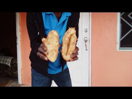 A farmer displays two Irish potatoes which are affected by a rare condition.