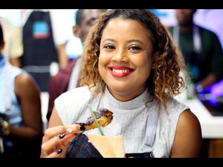 Digital and Fixed Media Manager at Restaurants Associates Limited Nicola-Kaye Barnett gets ready to sink her teeth into the air fried Red Stripe Sorrel Beer Chicken legs.