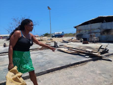 Melissa Walker points to the spot where her two shops once stood at the New Forum Fishing Village in Portmore, St Catherine. Her businesses were among 14 shops destroyed at the Urban Development Corporation-managed location earlier this month.