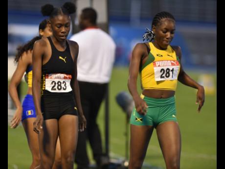 
Jamaica’s Rickiesha Simms (left) and Samantha Pryce walk it off after claiming a one-two finish in the girls’ under-20 1500 metres at the Carifta Games inside the National Stadium last evening.