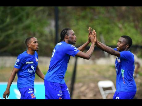 
Dunbeholden FC player Atapharoy ByGrave (centre) celebrates a goal with his teammates during a Jamaica Premier League game back in February. 