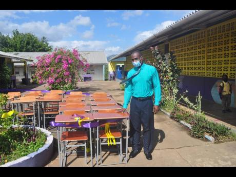 Bermaddy Primary School principal Melbourne Thompson examines the 40 desks and chairs that were gifted to the school by the parent-teacher association.