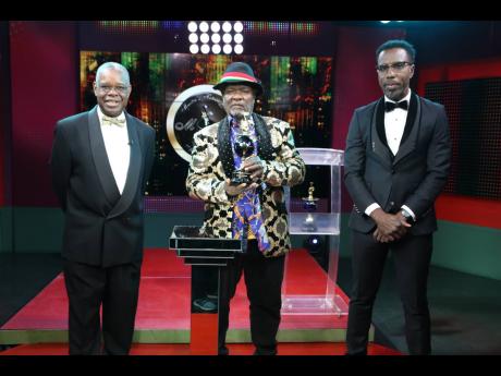 Bongo Herman receives one of the Icon awards at the 38th staging of the IRAWMA event. Looking on are organiser Ephraim Martin (left) and host Winford Williams.